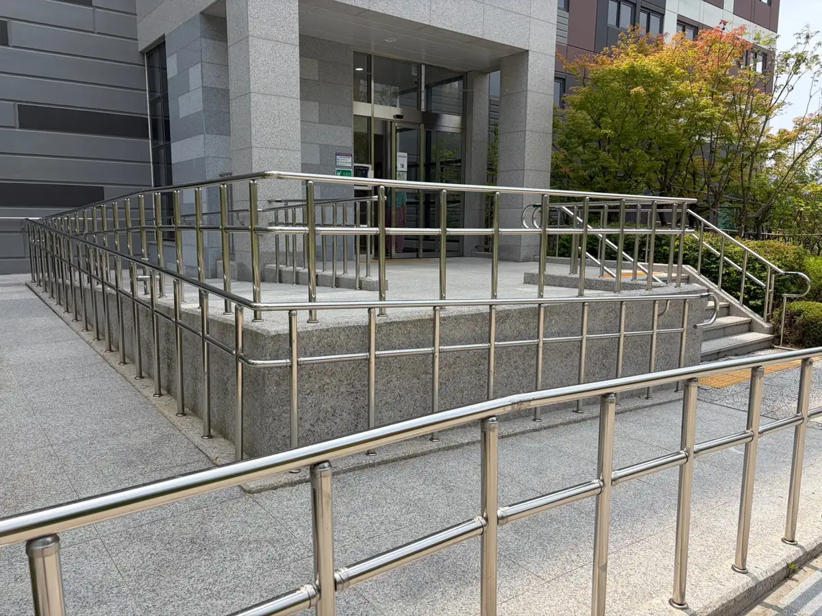 아파트 출입구 경사로 핸드레일 이어진 구간 근접